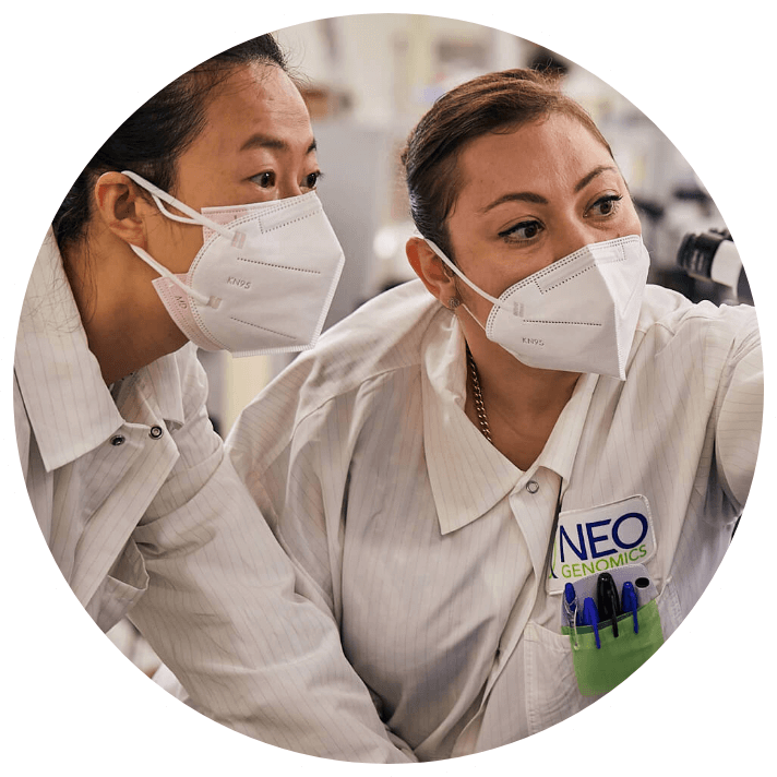 Two NeoGenomics lab employees looking at a monitor